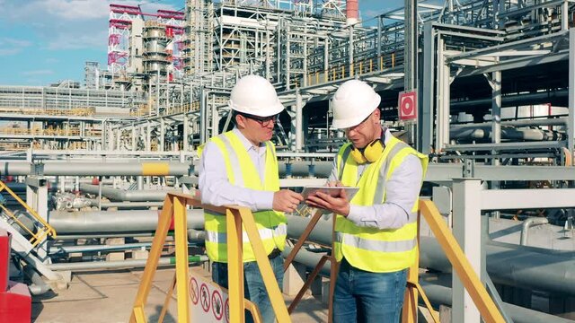 Refinery engineer is explaining a project to his colleague