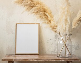 30x40 cm photo frame with pampas grass in a large jar on a bench near the wall