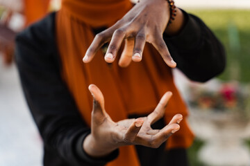 Fototapeta premium Close-up hands of black muslim woman at qigong chinese meditation and sport training outdoor. African girl is meditating outdoor near chinese arbor.