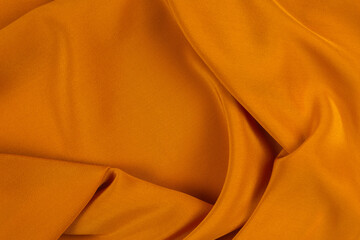 Golden silk or satin luxury fabric texture can use as abstract background.