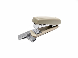 Staples piled with a stapler on white paper background