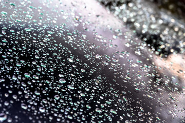 abstract shimmering water droplets on a car windshield after rain