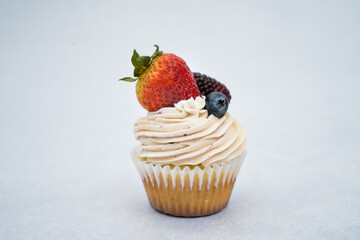 Tasty cupcakes with berries on a marble background