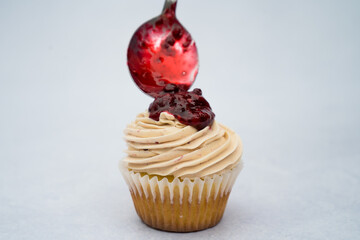 Tasty cupcakes with berries decorated with a spoon on a marble background