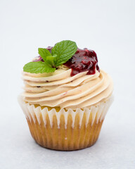 Tasty cupcakes with berries decorated with a spoon on a marble background