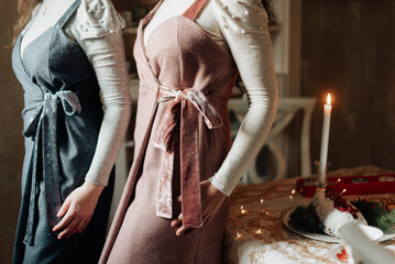 girls in beautiful long vintage dresses on the background of a burning candle