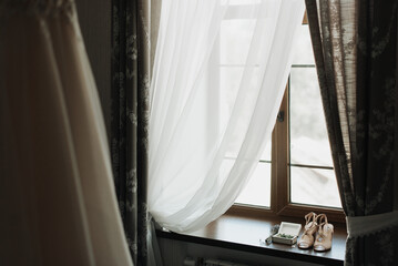 wedding shoes on the windowsill near the window close-up