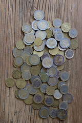 Euro coins of different countries lie on top of each other on a wooden table Cents from Europe