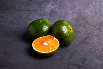 Fresh and juicy green mandarins on a dark background. Vegetarian food concept