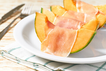 Fototapeta na wymiar Cantaloupe melon and prosciutto ham on a ceramic bowl.