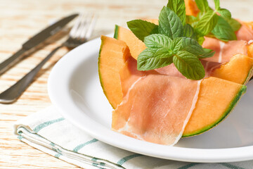 Cantaloupe melon and prosciutto ham on a ceramic bowl. concept italian food melon  and prosciutto selective focus.