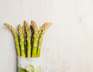 A bunch of fresh asparagus on a wooden gray table.