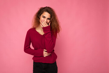 Photo of young happy positive pretty nice brunette wavy woman with sincere emotions wearing casual pink sweater isolated over pink background with empty space and laughing
