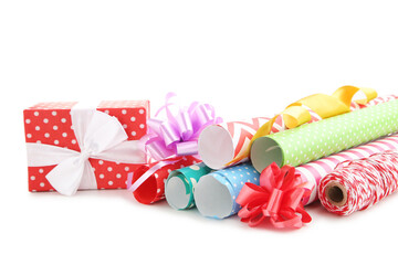 Rolls of craft papers with ribbon bows and gift box on white background