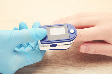 Doctor performs pulse oximeter test on human finger