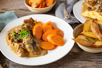 Home cooked meal with meat, potatoes, sauce and vegetables on a plate