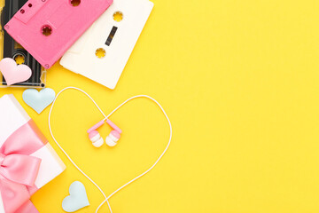 Earphones with cassette tapes and gift box on yellow background