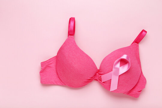 Ribbon with female bra on pink background