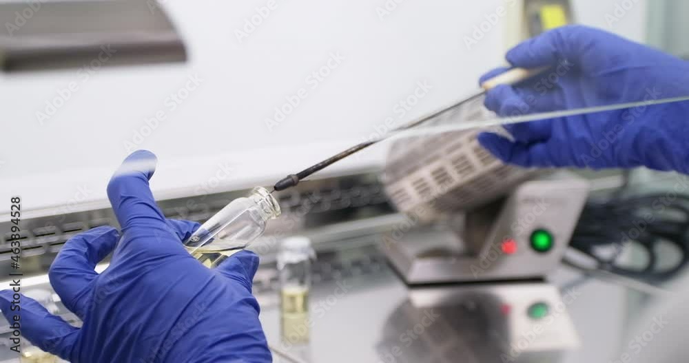 Canvas Prints A scientist works with bacteria in a sterile fume hood, uses a microbiological loop to introduce and stir the bacterial biomass in the culture medium of the vial.