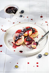 cheesecakes with blueberries on a white tile