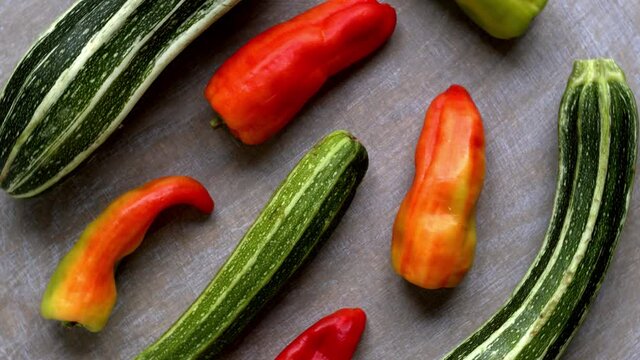 Fresh courgette vegetables and ripe cubanelle cultivar peppers. Organic vegetables top view with table spin.