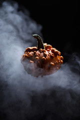 orange pumpkin floating in smoke