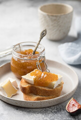 Crostini with brie cheese and fig jam served on ceramic plate. Healthy food concept. vertical image