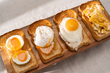 fried Toast bread with four different types of cooked chicken eggs, scrambled eggs, fried eggs, poached egg and creamed egg. Breakfast of chicken eggs. methods of making eggs for breakfast - 463896399