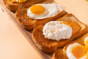 fried Toast bread with four different types of cooked chicken eggs, scrambled eggs, fried eggs, poached egg and creamed egg. Breakfast of chicken eggs. methods of making eggs for breakfast