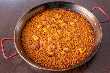 Delicious Spanish octopus paella with socarrat rice served in its paella pan