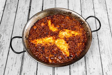 Sea and mountain paella with octopus, pork belly and Galician cheese in its paella pan