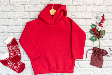 Red fashionable kids sweatshirt with a hood with clothes hanger on white background top view....