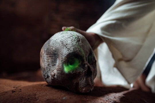 a man in the makeup of a dead man. a gloomy gothic image for Halloween. a skull with burning eyes. white cape and fire