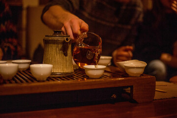Photo of white cups with tea on a brown wooden tray in a cafe