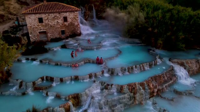 Saturnia thermal baths, Grosseto, Tuscany, Italy,Hot springs Cascate del Mulino man and woman in hot spring taking a dip during morning with fog