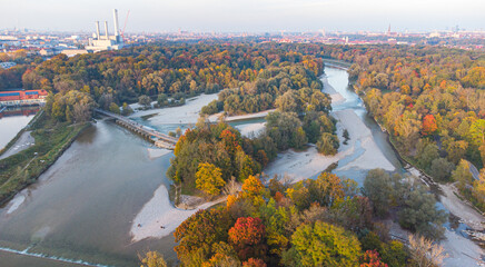 Aerial views of autumn in Munich. Isar river seen from above with colorful trees nearby