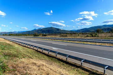 Empty silent Freeway. Summer country road. Rural environment road. Nature road. 
Asphalt road. Landscape with empty asphalt road through woodland in summer. Travel. Road trip