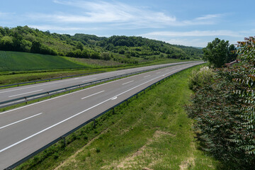 Empty silent Freeway. Summer country road. Rural environment road. Nature road. 
Asphalt road. Landscape with empty asphalt road through woodland in summer. Travel. Road trip