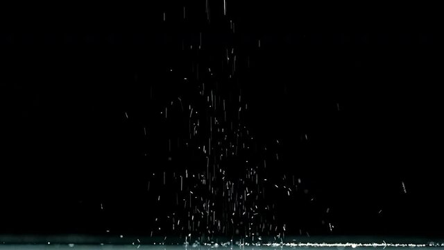 The falling white particles on a black background. slow motion