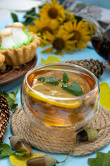Hot lemon tea and cookies with cream frosting, on a wooden table, selective focus

