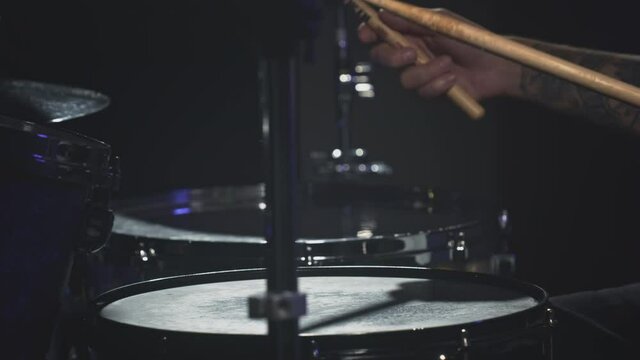 Male Artist hits snare drum, drum kit. Night show in a musical instrument recording studio. The drummer on the Repetition of rock or metal music band. Musical party. Slow motion