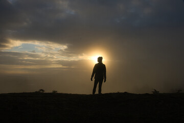 silhouette of a person standing on a hill