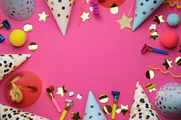 Flat lay composition with party hats and other festive items on bright pink background. Space for...