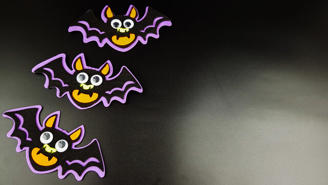 funny cartoon bats on a black background. there are places for a copy .