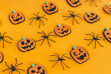 Happy Halloween. Pumpkins jack o lantern and spiders on orange background. Halloween decorations layout on yellow paper. Halloween background. Festive pattern