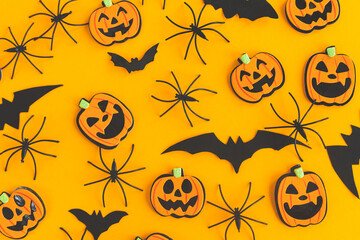 Halloween background. Modern pumpkins jack o lantern, spiders, bats layout on orange background. Happy Halloween flat lay. Halloween decorations pattern on yellow paper