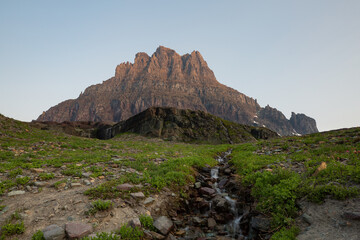 Clements mountain catches the first light of a summer day as melting snow forms into small...