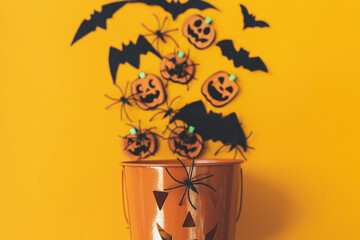 Happy Halloween. Jack o lantern bucket with spiders, bats and pumpkins on orange background top...