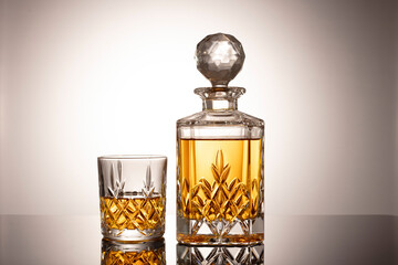 Cognac or brandy on a glossy table on an isolated gray background