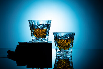 glass of whiskey on blue background